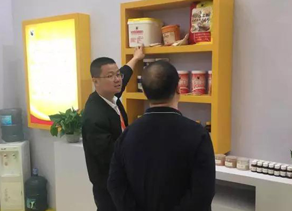 業(yè)務(wù)員周明華在向客人介紹牛乳香粉、速發(fā)蛋糕油等產(chǎn)品。